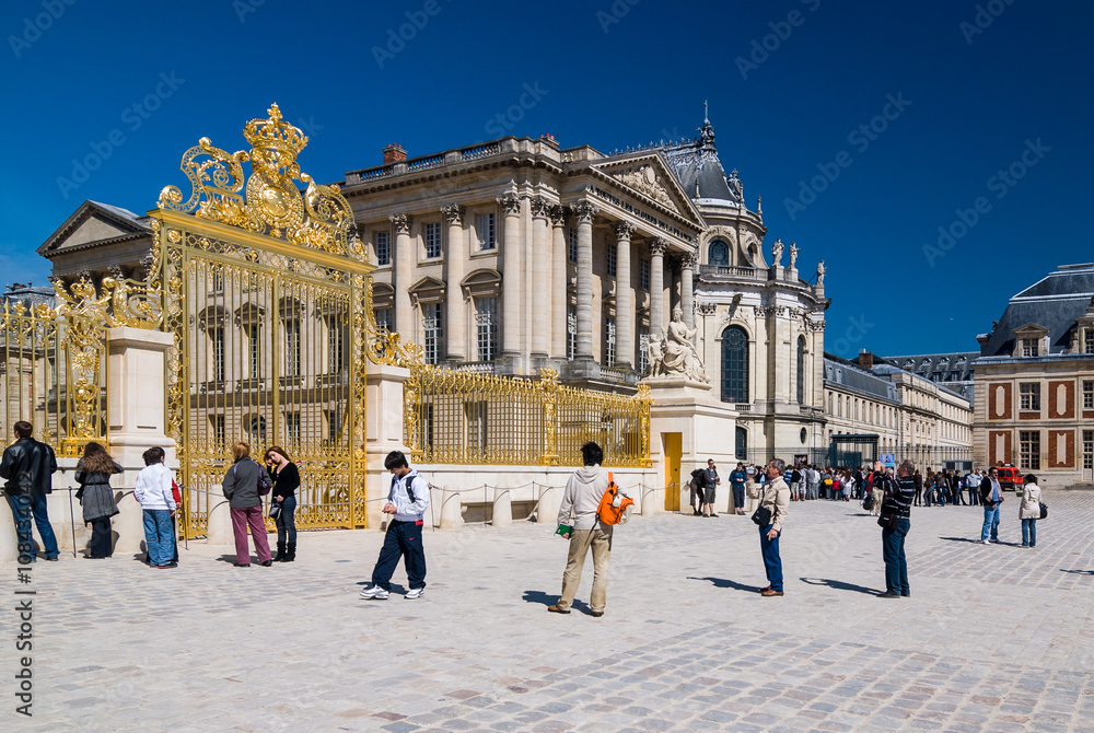 Obraz premium VERSAILLES, FRANCE - April 24, 2009: Tourists in front of main Golden Gate of Palace of Versailles in Paris, France.