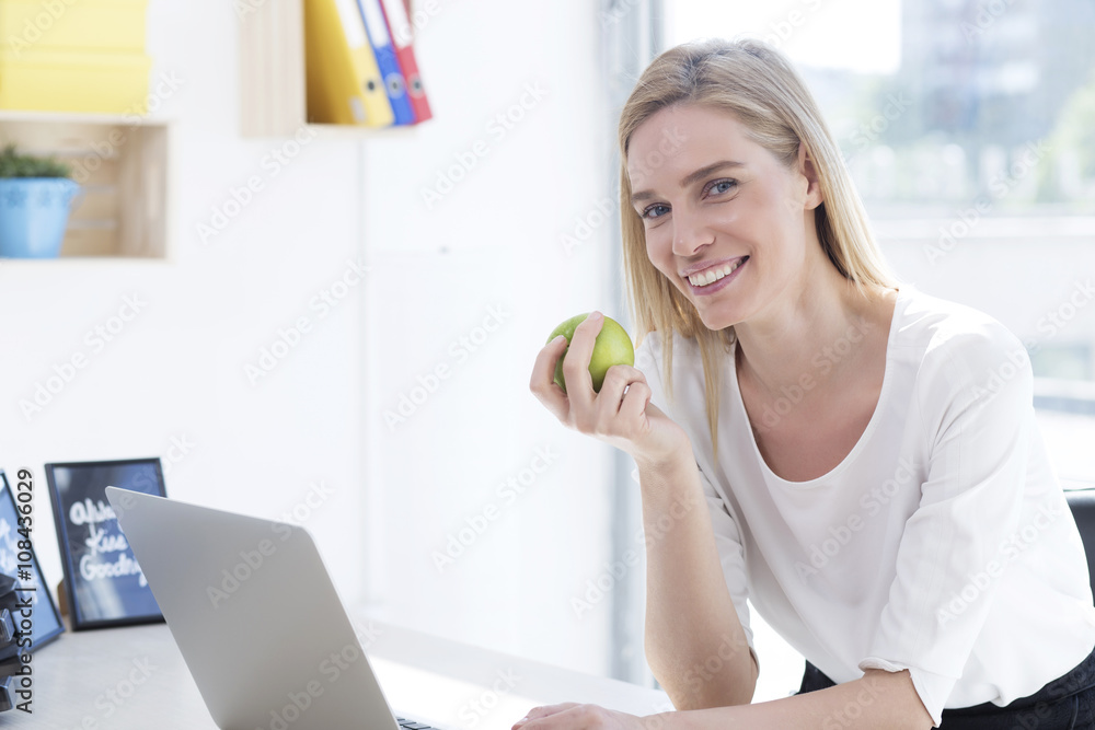 Businesswoman having healthy snack, eating apple Businesswoman having healthy snack, eating apple