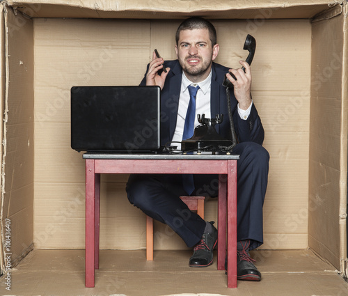 businessman leading two calls at the same time, box office photo