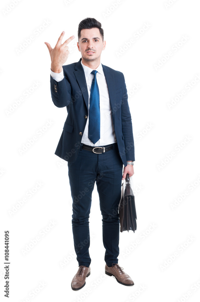 Sales man standing holding briefcase and showing number three Sales man standing holding briefcase and showing number three