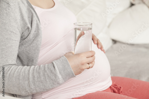 Schwangere hält Wasser in Hand photo