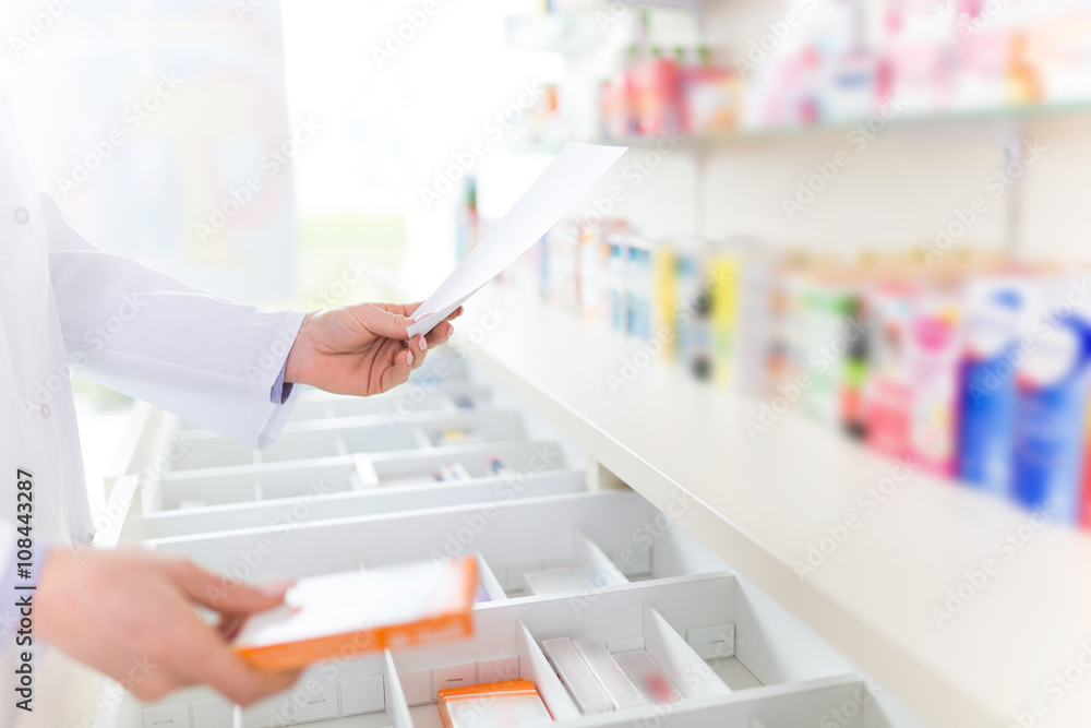 Pharmacist filling prescription in pharmacy - obrazy, fototapety, plakaty 