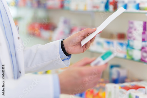 Pharmacist filling prescription in pharmacy photo