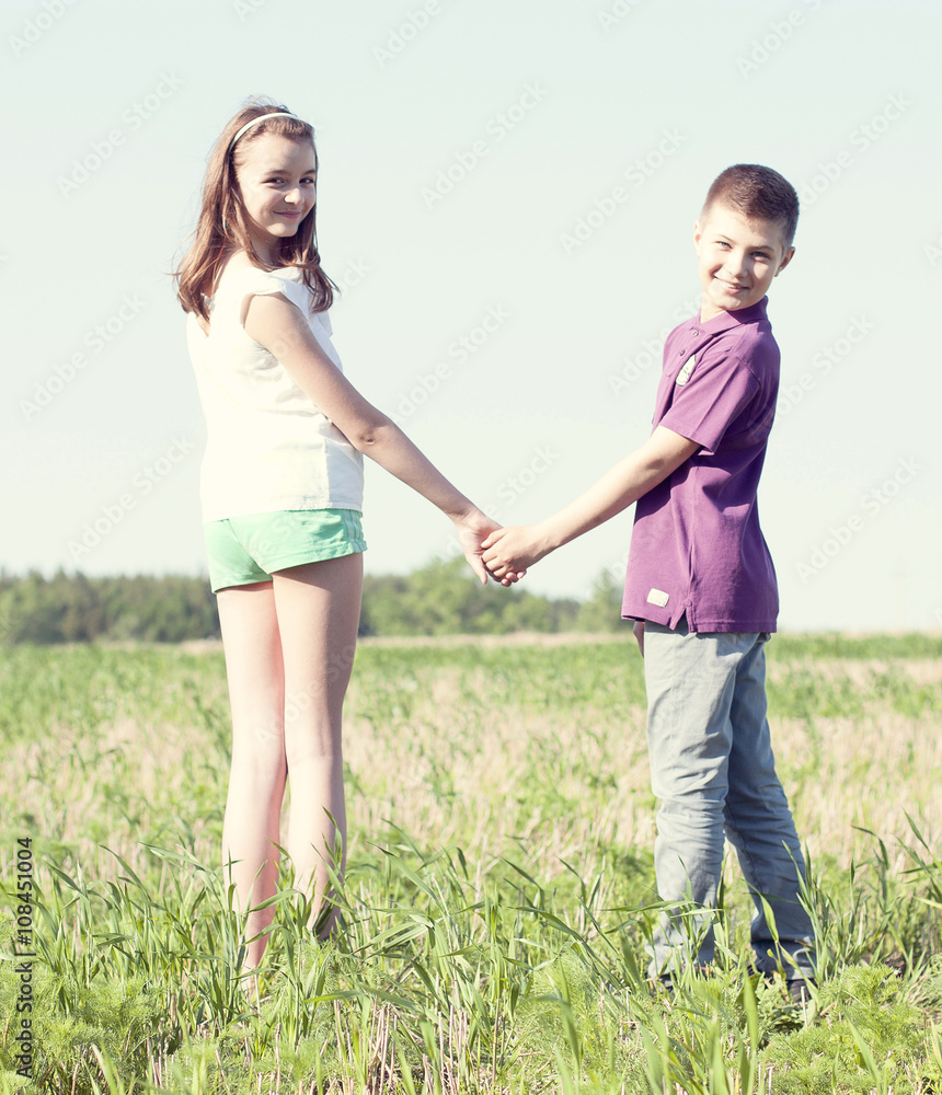 Summer sunny day park stands boy with girl holding hands enjoy nature, Meadow, fun small little family relationships, idea concept happiness lifestyle Summer sunny day park stands boy with girl holding hands enjoy nature, Meadow, fun small little family relationships, idea concept happiness lifestyle
