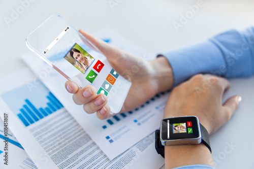 close up of hands with smart phone and watch