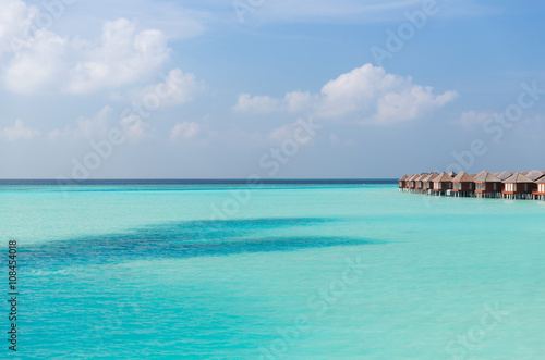 bungalow huts in sea water on exotic resort beach © Syda Productions