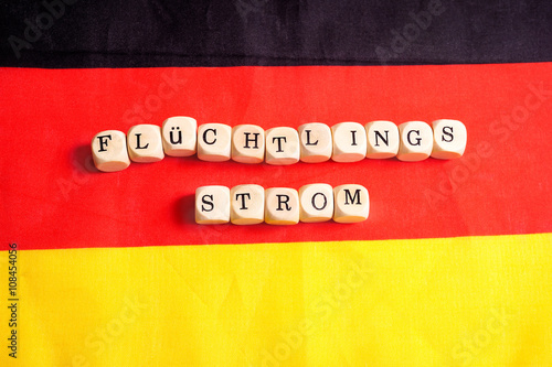 Flüchtlingsstrom, Buchstabenwürfel auf Deutschlandfahne