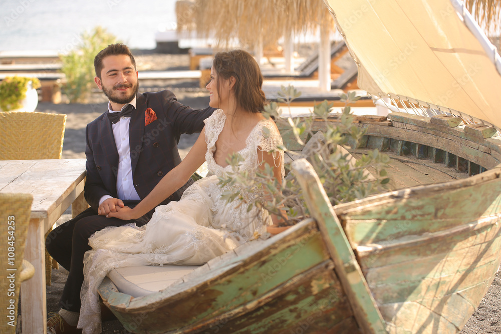 Fototapeta premium bride and groom relaxing on a wooden boat