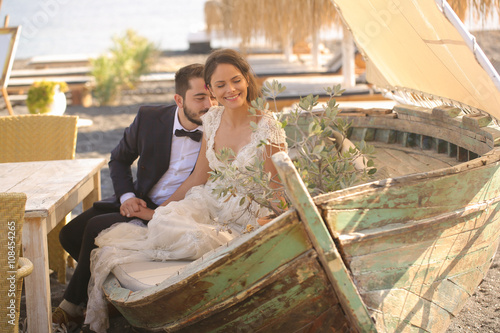 Fotografie bride and groom relaxing on a wooden boat
