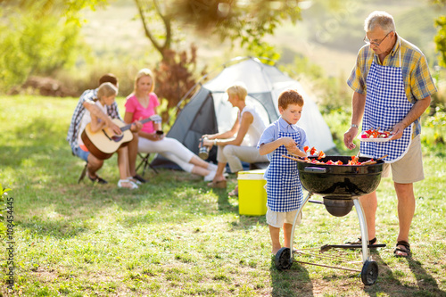 family on camping making barbecue