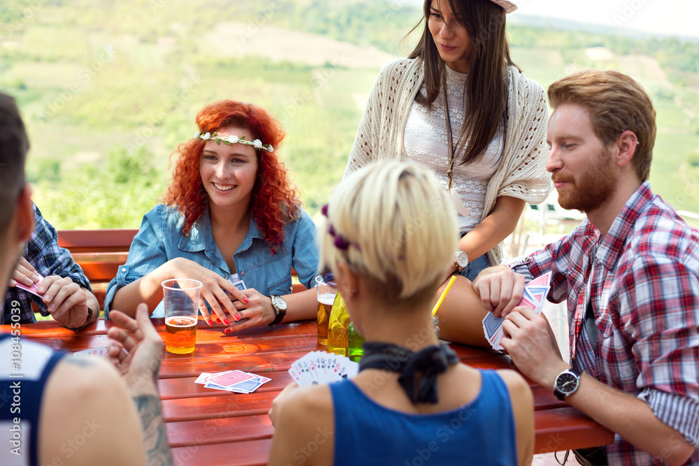 Youth having fun while drink beer and plays cards