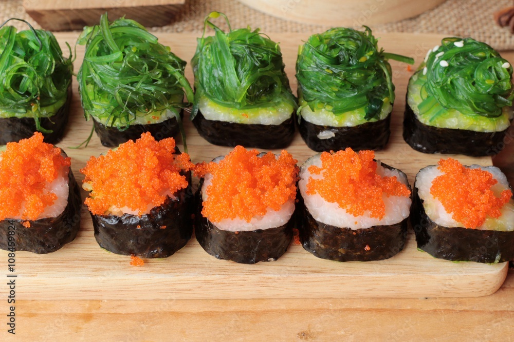 Sushi roll with seaweed salad and shrimp eggs. Sushi roll with seaweed salad and shrimp eggs.