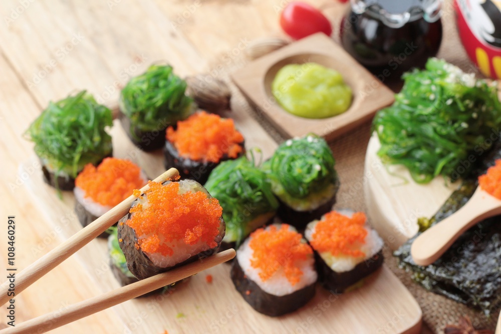 Sushi roll with seaweed salad and shrimp eggs. Sushi roll with seaweed salad and shrimp eggs.