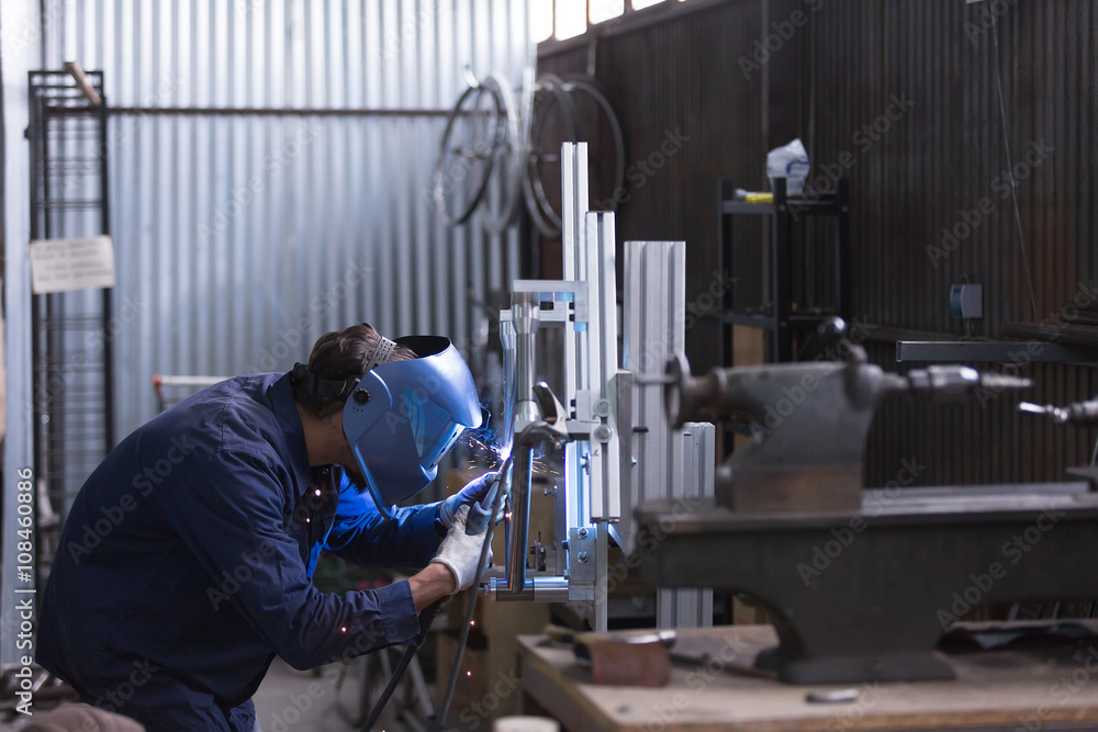 Side view of worker with welding machine Side view of worker with welding machine