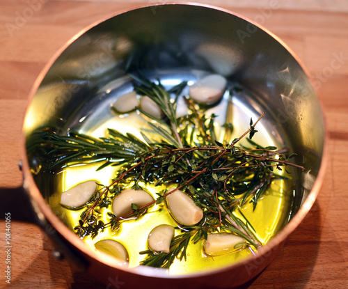 Garlic, thyme and rosemary in bowl with olive oil