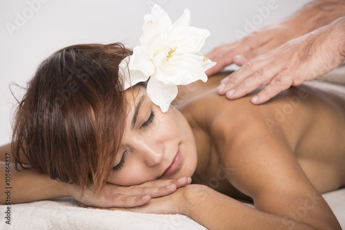 Ragazza con fiore in testa nel lettino per massaggi