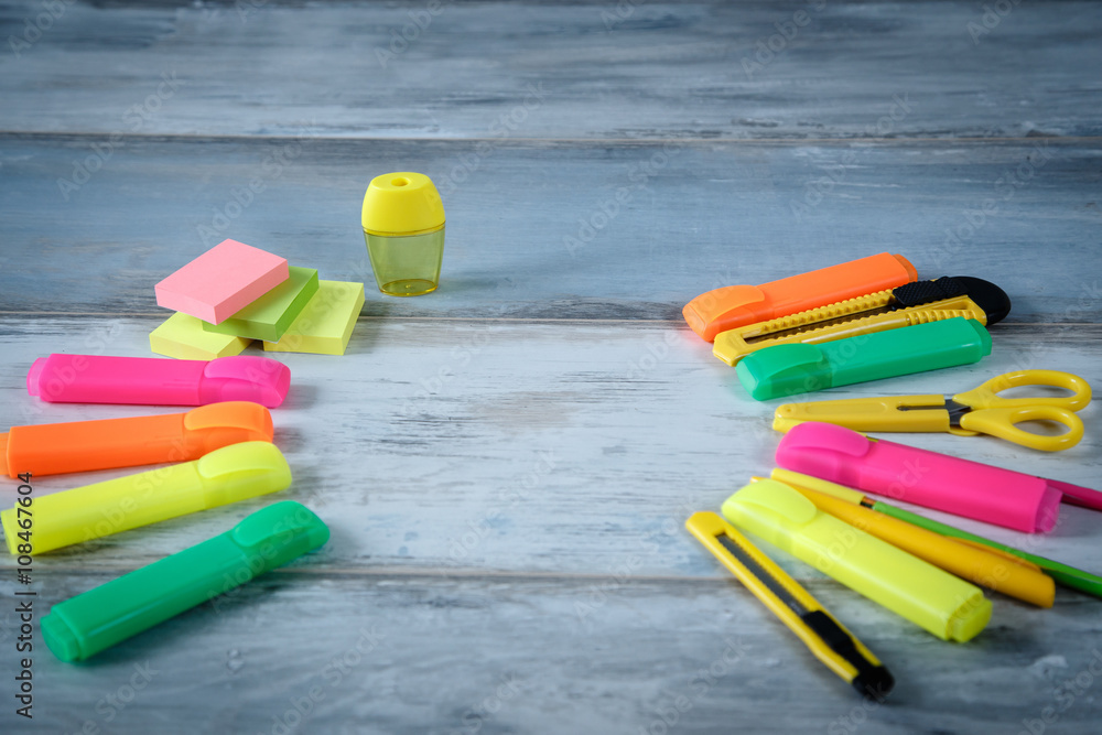 Naklejka premium Different pens pencils markers clean notebook and other stationery on the blue vintage wood background copy space