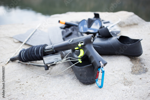 Equipment for underwater hunting near the pond on the rock. 