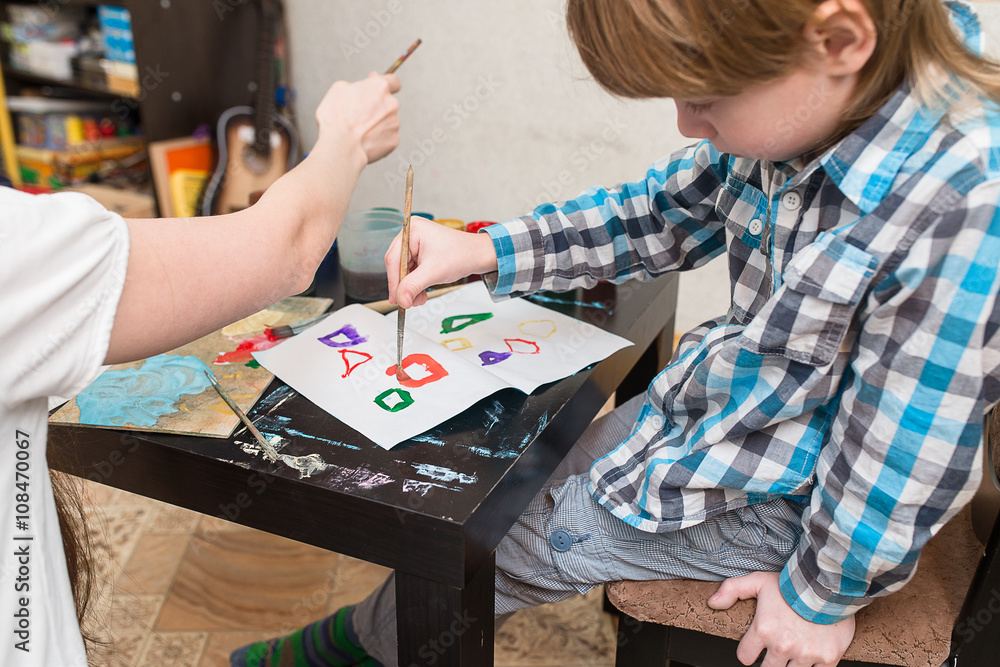 Fototapeta premium mother with boys son paint colors at home