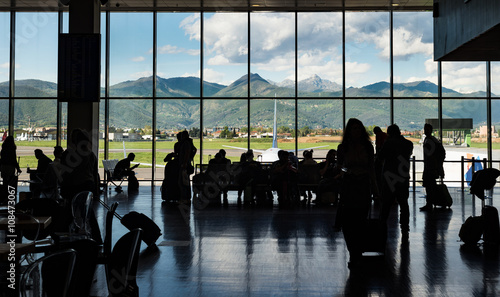 Silhouette crowd people waiting for aiplane in terminal with mountain background, Milano Bergamo airport photo