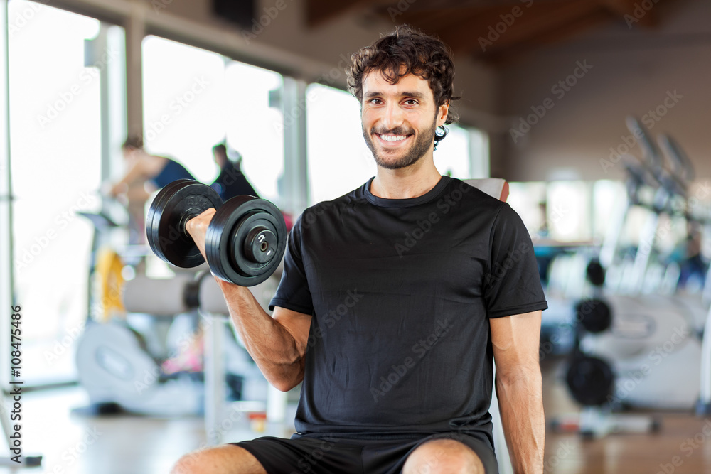 Man lifting a weight in a fitness club Man lifting a weight in a fitness club