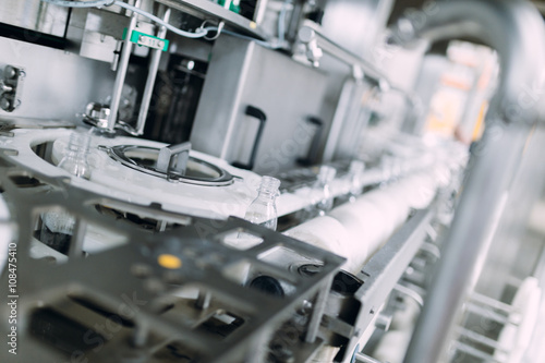 Robotic factory line for processing and bottling of pure spring water into canisters and bottles. Selective focus. Short depth of field.