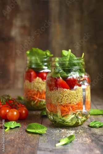 Salad with quinoa and vegetables in a mason jar.