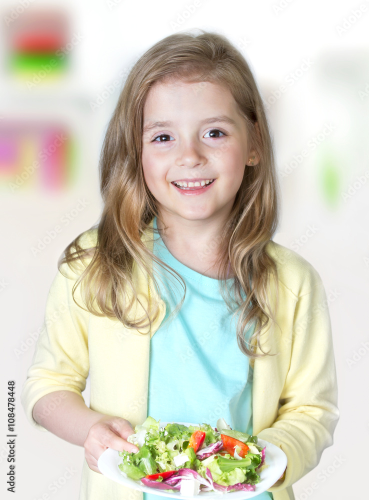 Child girl smiling holding fresh salad.Healthy nutrition. Child girl smiling holding fresh salad.Healthy nutrition.