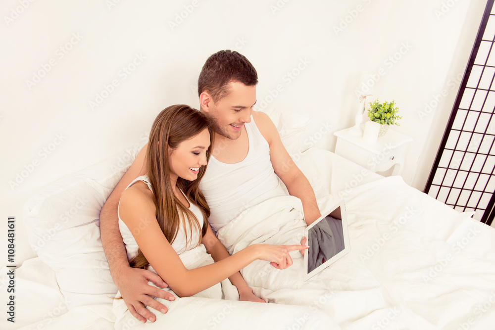 portrait of girl doing internet shopping with her husband portrait of girl doing internet shopping with her husband