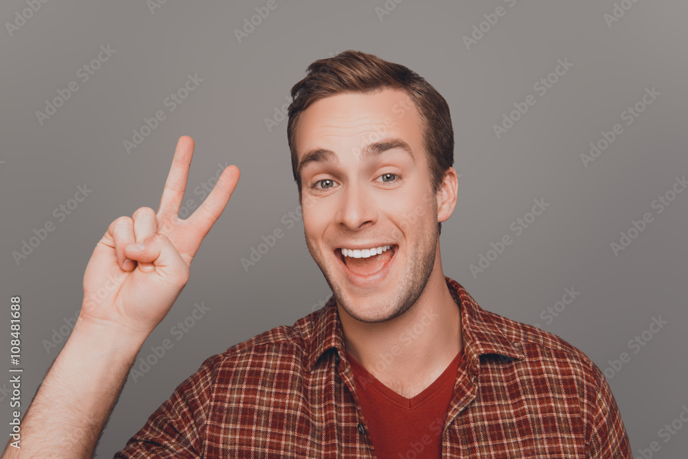 Close up portrait of smiling man showing two fingers Close up portrait of smiling man showing two fingers
