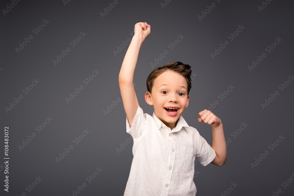 Yes! Happy little boy triumphing with raised hands Yes! Happy little boy triumphing with raised hands
