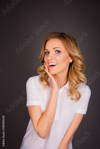 Beautiful happy smiling woman touching her face on gray backgrou