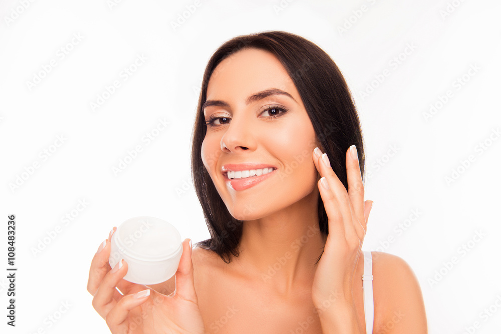 Young attractive girl applying cream on her face Young attractive girl applying cream on her face