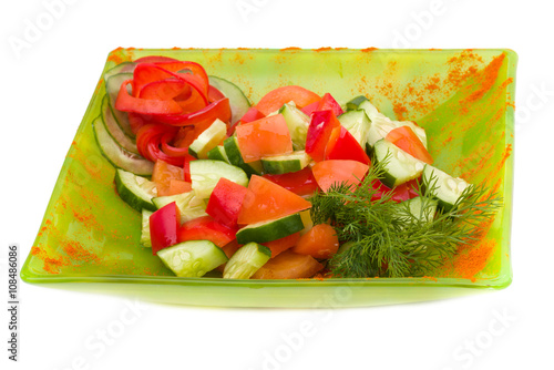 sliced tomato and cucumber with lettuce isolated on white