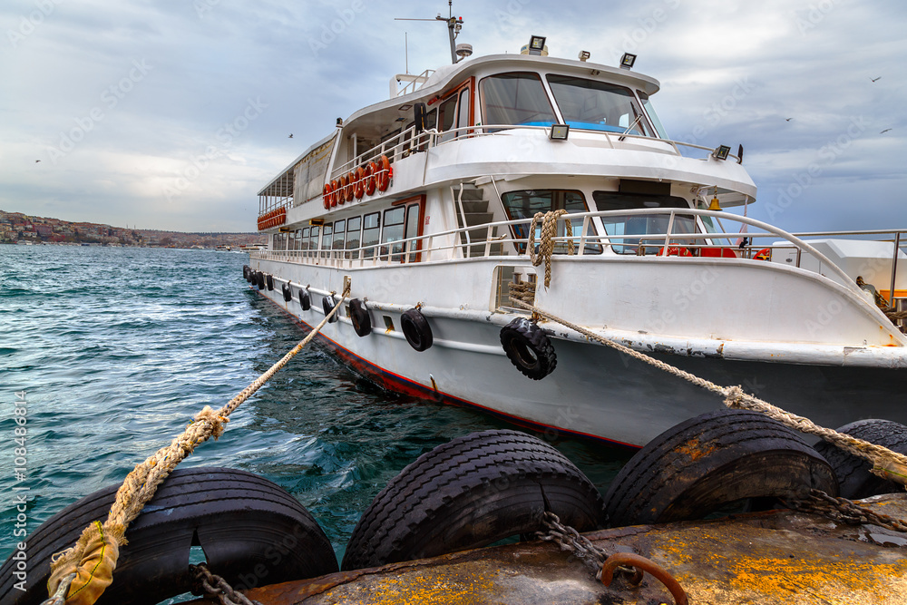Fototapeta premium Passangers' boat, moored by the pier, Istanbul, Bosphorus channel.