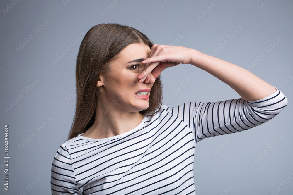 Pleasant girl closing her nose Pleasant girl closing her nose