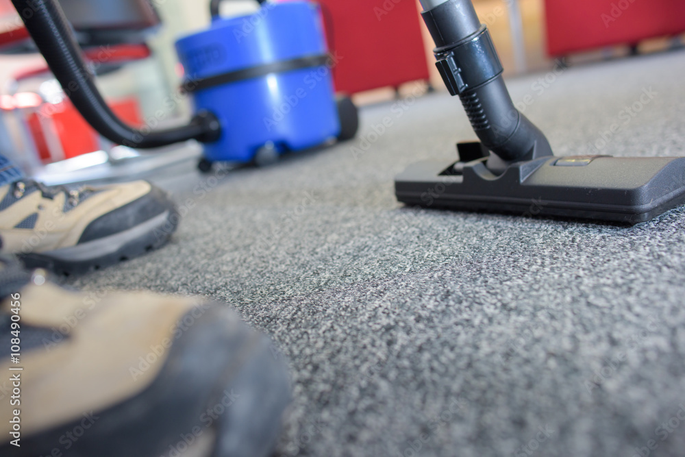 Closeup of male feet and vacuum cleaner Closeup of male feet and vacuum cleaner