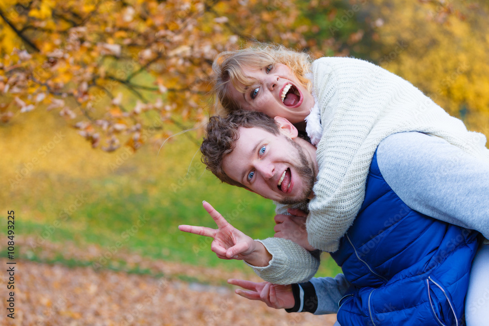 Fototapeta premium Man giving piggyback ride to woman in park