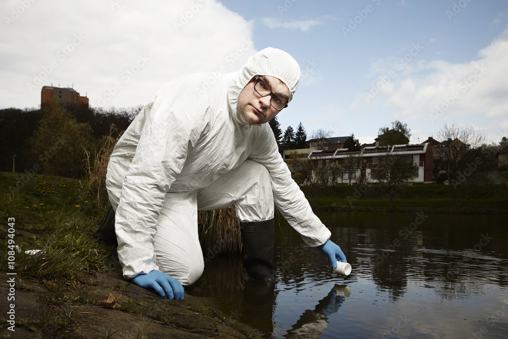 Technician in terrain collecting samples of water Technician in terrain collecting samples of water