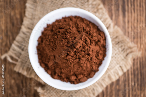 Cocoa powder on wooden background