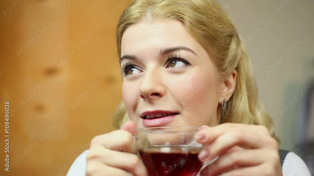 Smiling blond woman drinking tasty tea and thinking about life, happy times Smiling blond woman drinking tasty tea and thinking about life, happy times