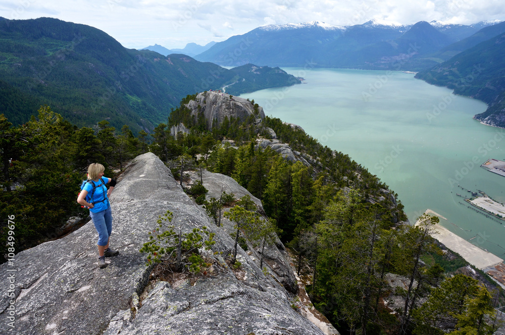 Woman Enjoying View from Mountain Top. 
Stawamus Shief Provincial Park, British Columbia, Canada. 