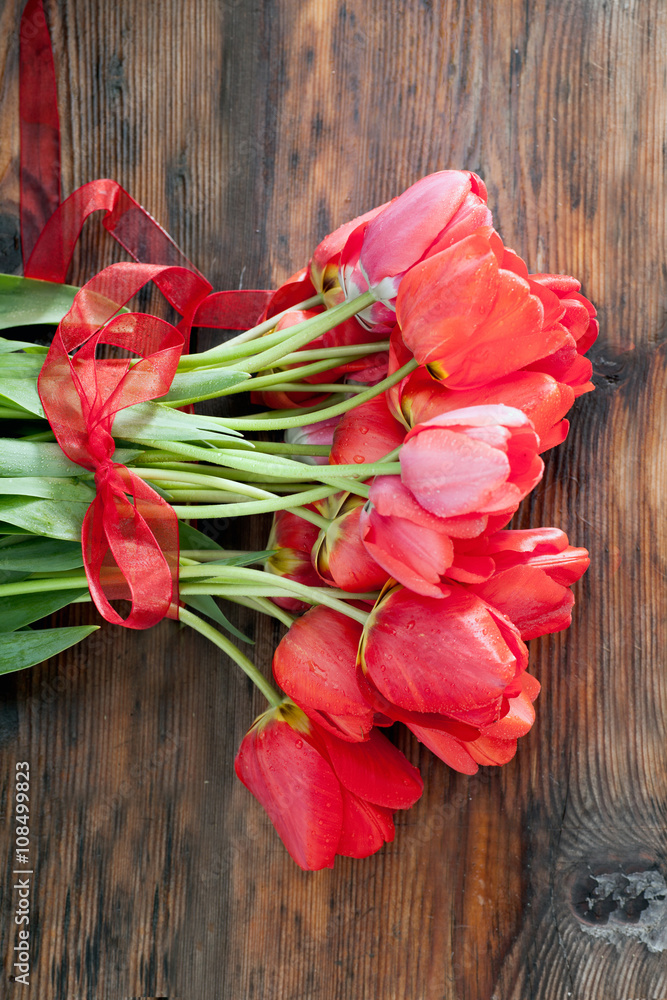 Beautiful red tulips on wooden background