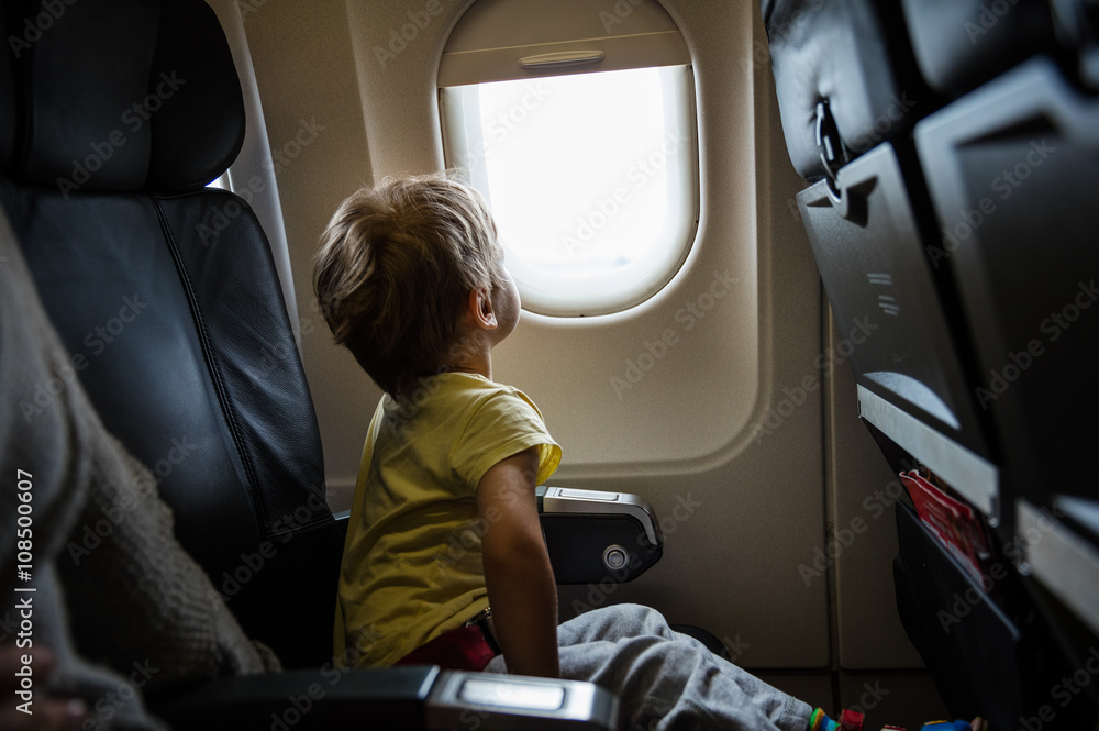 Boy looking out of window in airplane Boy looking out of window in airplane