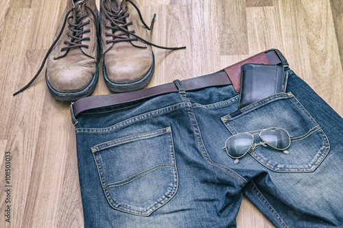 Jeans, belt ,shoes and wallet on wood floor