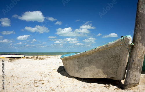 Boat on a beach under a cloudy blue sky