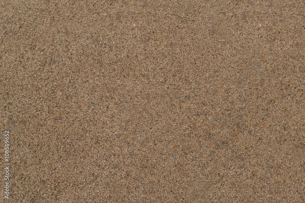 Wet sand. Texture. Smooth surface of wet sand is dark yellow in color. Stock Photo Adobe Stock