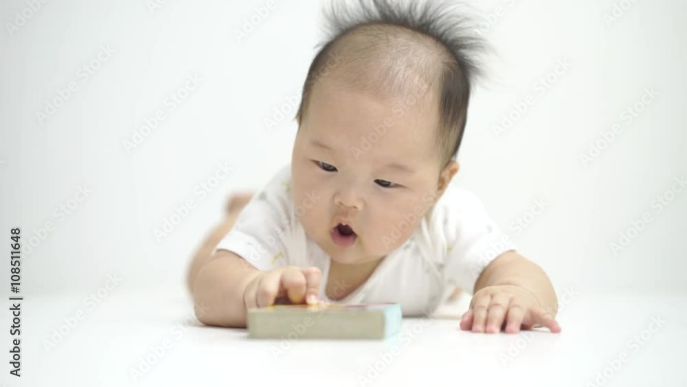 Asian chinese baby reading a cute little tiny book. Asian chinese baby reading a cute little tiny book.