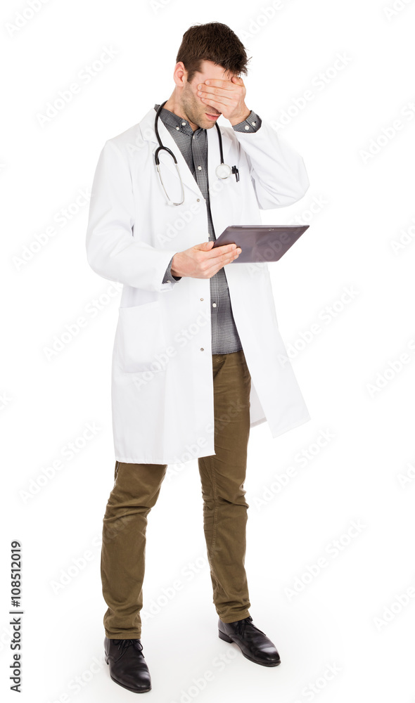 Male Caucasian doctor holding a digital tablet, looking shocked Male Caucasian doctor holding a digital tablet, looking shocked