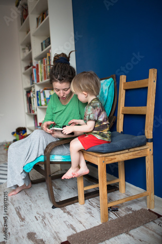 Mother reading with her son at home, casual,